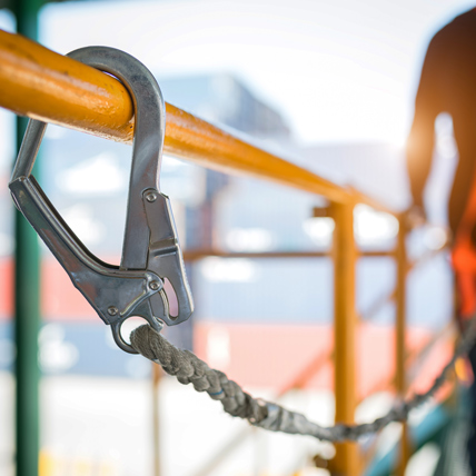 Construction worker using a harness rope on a catwalk at a jobsite. 