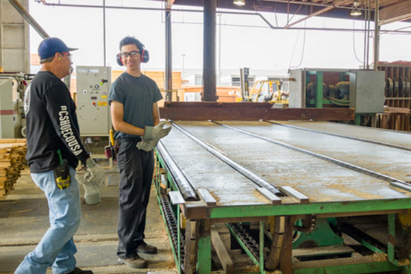 Two employees working in the custom millshop. 