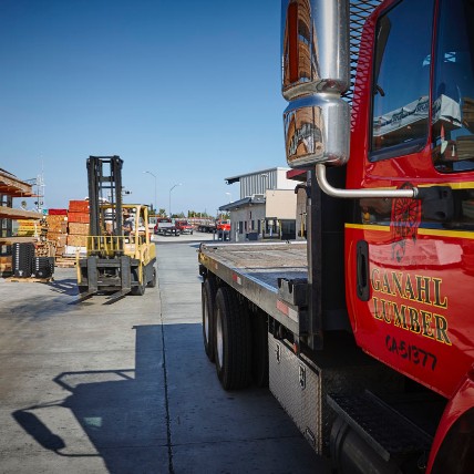 Ganahl Lumber delivery truck and forklift in the lumberyard. 