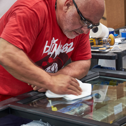 A Ganahl employee setting a window pane in the custom mill shop.