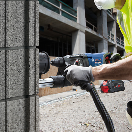 A construction worker using a Bosch tool at a worksite. 