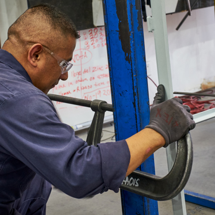 A Ganahl employee working with a large hand tool. 