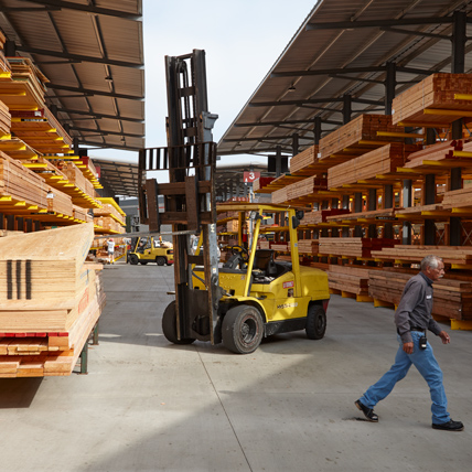 Ganahl Lumber employee in front of a forklift in the lumber yard.