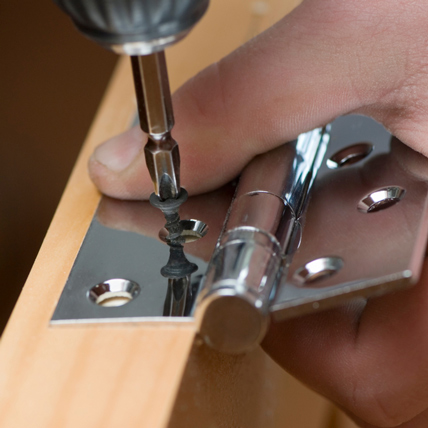 Phillips screw driver putting on a door hinge