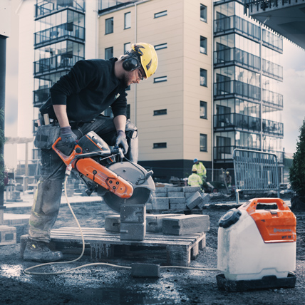Construction worker using a circle saw to cut through cinder blocks. 