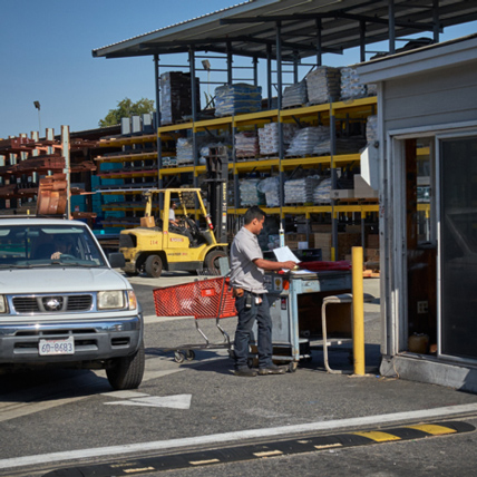 A Ganahl lumberyard employee checking out a customer as they leave the lumberyard.